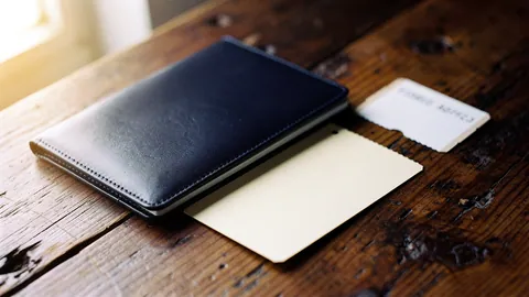 Illustration: A passport and paper ticket on a wooden travel table.