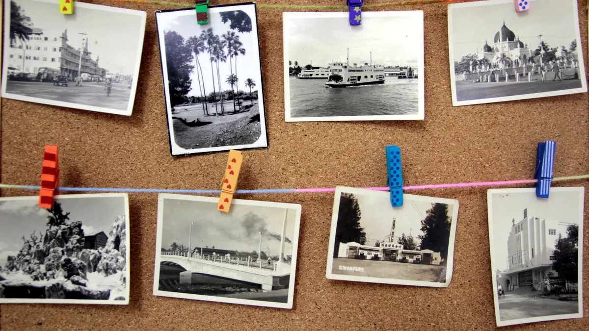 Faded photographs pinned to a corkboard in a spare room.
