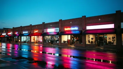 Illustration: Downtown Nashville storefronts glowing with neon at evening.