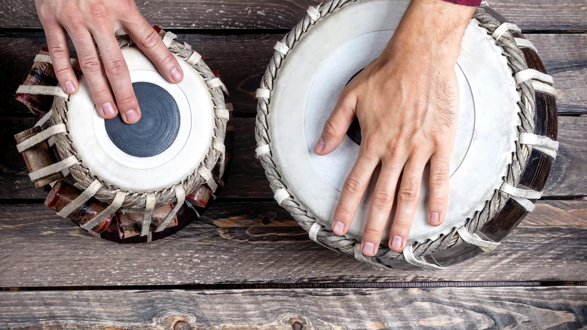 A hand drum on a wooden floor in golden afternoon light.